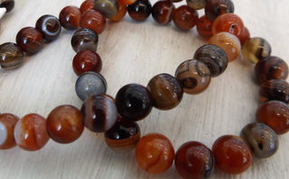 Agate (8mm rounds) 15.5" strand.  approx 43 beads.  Striped Browns/ Nat Oranges